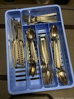 Entire blue tray containing assorted flatware pieces