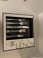 Boxed Lenox French Perle flatware set showing utensils through window