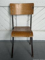Front view showing full chair, plywood surfaces, metal frame