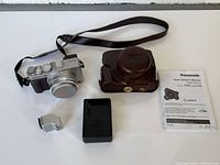 All included items laid out: camera, case, charger, flash, manual