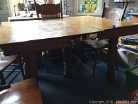 Full view of the vintage wooden rectangular table showing the top surface and turned legs under natural light.