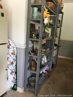 Two gray metal shelving units placed side by side, each with five shelves holding various decorative and household items (not included). Units have vertical metal frame with perforated edges for shelf adjustment.