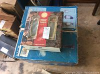 Two boxed brass outdoor wall lanterns labeled as Manor House model 2036-02TWN, visibly new in packaging.