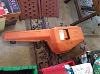Orange Husqvarna branded hard carrying case closed, containing the chainsaw.