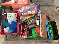 Lot overview including Barbie doll in box, Lisa Frank folders, toy containers, and sand art materials.