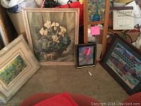 Photo showing all five pieces of wall art stacked against a wall, including the peacock mosaic mirror and four framed pictures.
