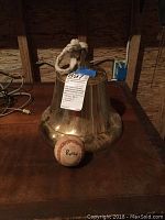 Photo showing baseball with name Betts written on it next to a brass bell.