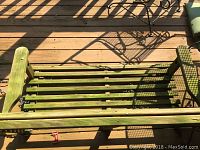 Top-down view of the green-stained wooden slatted bench swing showing its overall shape and construction.