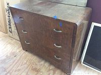 Photo of the metal dresser showing three drawers with handles and wood grain finish.