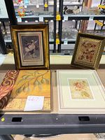 Front view of three framed prints and one plaque