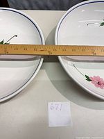 Two white ceramic bowls side by side with ruler showing diameter