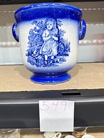 Front view showing girl scene, color, handles, footed base