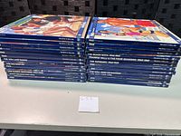 Stacked view of both piles of blue-spined gatefold sleeves