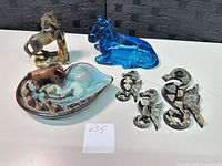 Group shot of all items: glass horse, ceramic horse, pottery dish, four seahorse ornaments