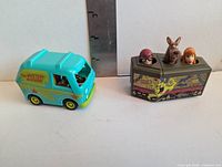 Mystery Machine van and coffin toys side by side for scale