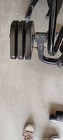 Three weight plates mounted on resistance arm of bench