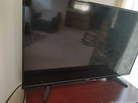 Front view of Toshiba TV on wooden console