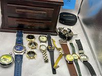 Overall view showing wooden box, pocket watch, wristwatches, loose bands and accessories