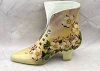 Right side view of porcelain shoe vase showing floral design and button holes