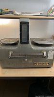 Front view of Franklin Electric Shadograph double-pan balance scale showing both weighing pans, beam, and serial label