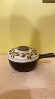 Side view showing saucepan body, handle, and lid