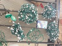Five loose LED strands, boxed strand and green spotlight on mesh table