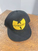 Front view of black cap with yellow Wu-Tang logo