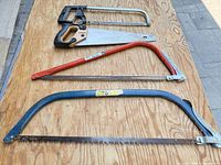 All four saws laid out on plywood surface