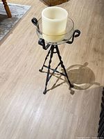 Full view of wrought iron stand with glass bowl and candle