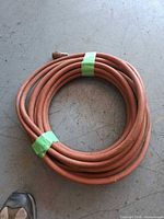 Coiled reddish-orange rubber air hose on floor