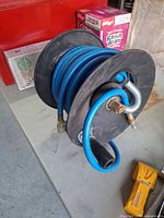 Reel showing hose wound, brass fitting and handle