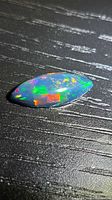 Top view of marquise cabochon opal showing vivid colour play