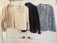 All four sweaters hanging on door for overview