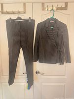Full view of blazer and trousers hanging on door