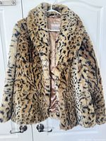 Front view of faux fur leopard-cheetah print jacket on hanger