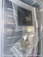 Two small plastic bags with chain and metal piece atop bin lid