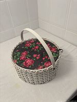 Overall view of wicker sewing basket with floral lid and handle