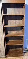 Front view showing five shelves and woodgrain laminate