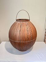 Full view of spherical bamboo basket on table