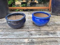 Both cobalt blue ceramic planters side by side on deck
