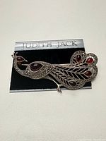 Front view of Judith Jack peacock brooch on card