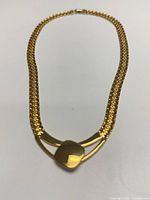 Full view of necklace laid flat showing overall design and clasp