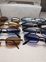 Multiple pairs of sunglasses laid out showing frame styles and lens colors