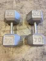 Both 70 lb dumbbells side by side on floor