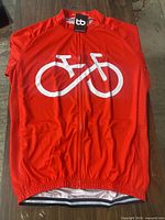 Front view of red cycling jersey folded on table