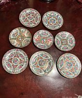 Eight saucers laid flat showing full pattern