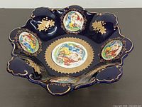 Top view showing romantic scene panels, scalloped rim, gold detailing