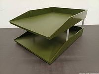 Front right perspective showing two olive green trays and metal supports