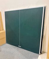 Two green tabletop halves standing upright