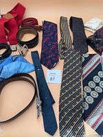 Group shot of ties, belts, suspenders and light blue pocket square